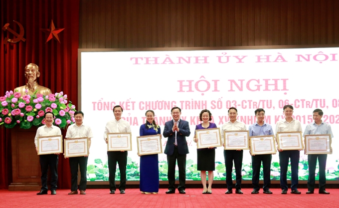 Bí thư Thành ủy Hà Nội Vương Đình Huệ trao tặng bằng khen cho các tập thể, cá nhân có thành tích xuất sắc trong thực hiện các chương trình lớn của Hà Nội xây dựng Đảng. (Ảnh: TA)