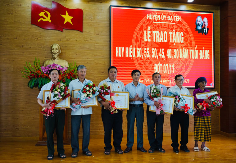 Đồng chí Nguyễn Mạnh Việt – Phó Bí thư Thường trực Huyện ủy Đạ Tẻh trao Huy hiệu Đảng cho các đảng viên. (Ảnh: HS)
