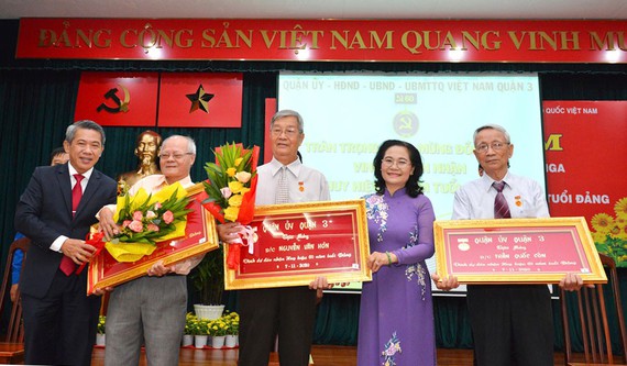 Chủ tịch HĐND TPHCM Nguyễn Thị Lệ trao Huy hiệu 70 năm tuổi Đảng cho đồng chí Nguyễn Đình Tiểu. (Ảnh: VIỆT DŨNG)