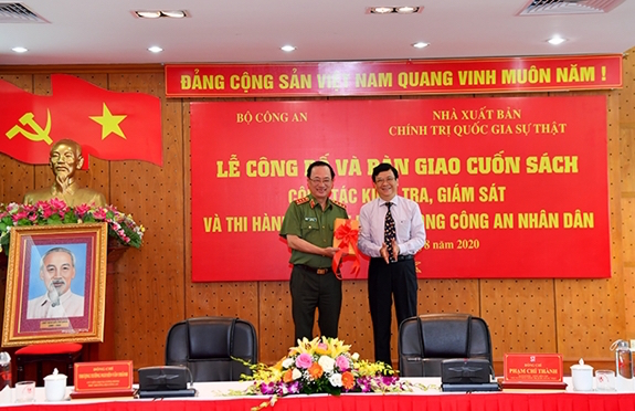 Thượng tướng Nguyễn Văn Thành, Thứ trưởng Bộ Công an nhận bàn giao cuốn sách từ Quyền Giám đốc Nhà xuất bản Chính trị quốc gia – sự thật Phạm Chí Thành