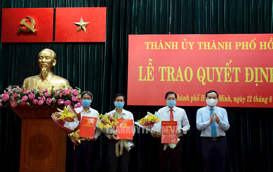 Đồng chí Trần Lưu Quang trao quyết định và tặng hoa chúc mừng các đồng chí nhận nhiệm vụ mới. (Ảnh: Long Hồ)