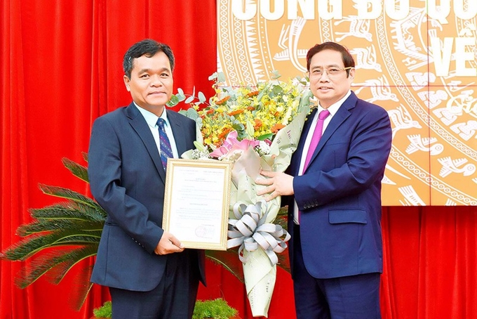 Đồng chí Phạm Minh Chính trao quyết định và chúc mừng đồng chí Hồ Văn Niên.