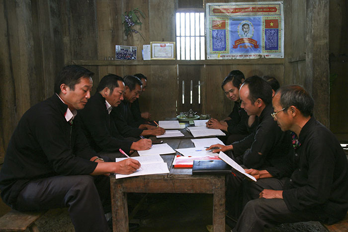 Bí thư Ðảng ủy xã Sín Chải Thào A Nhè (bên trái) dự buổi sinh hoạt chi bộ tại bản Sín Chải.
