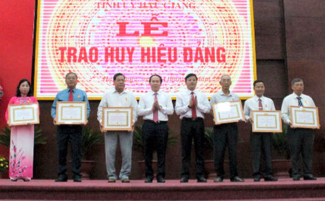 Lãnh đạo tỉnh Hậu Giang trao và chúc mừng các đảng viên nhận Huy hiệu Đảng (Ảnh: Gia Nguyễn)