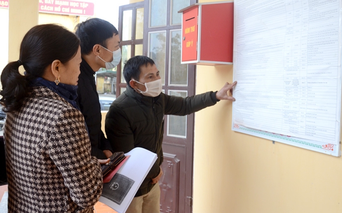 Người dân tìm hiểu thời gian thực hiện công tác bầu cử Quốc hội khóa XV và HĐND các cấp nhiệm kỳ 2021 - 2026 được niêm yết tại thị trấn Sơn Dương.