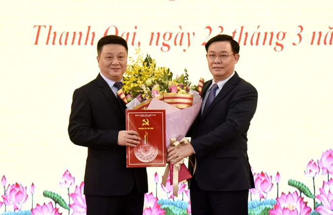 Bí thư Thành ủy Hà Nội Vương Đình Huệ đã trao Quyết định của Ban Thường vụ Thành ủy và tặng hoa chúc mừng tân Bí thư Huyện ủy Thanh Oai Bùi Hoàng Phan.