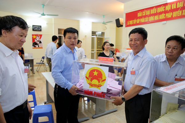 Bàn giao các hòm phiếu cho thành viên Tổ bầu cử để tiến hành kiểm phiếu. (Ảnh minh họa: baochinhphu.vn)