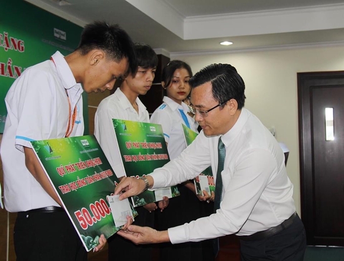 PGS.TS Nguyễn Đình Tứ, Chánh văn phòng ĐHQG- HCM, Giám đốc Quỹ phát triển ĐHQG-HCM  trao học bổng toàn phần cho sinh viên có hoàn cảnh khó khăn .