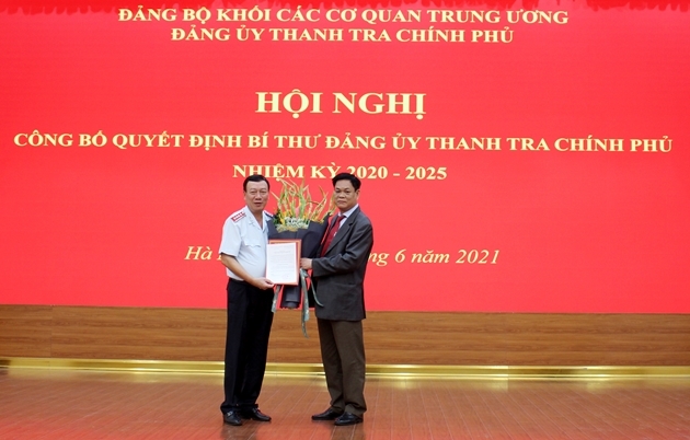 Đồng chí Huỳnh Tấn Việt trao quyết định và tặng hoa tân Bí thư Đảng ủy TTCP Đoàn Hồng Phong (trái ảnh). Ảnh: LP.
